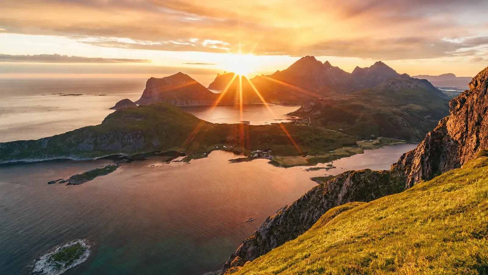 Sunset over a fjord with mountains, lake, and coastline